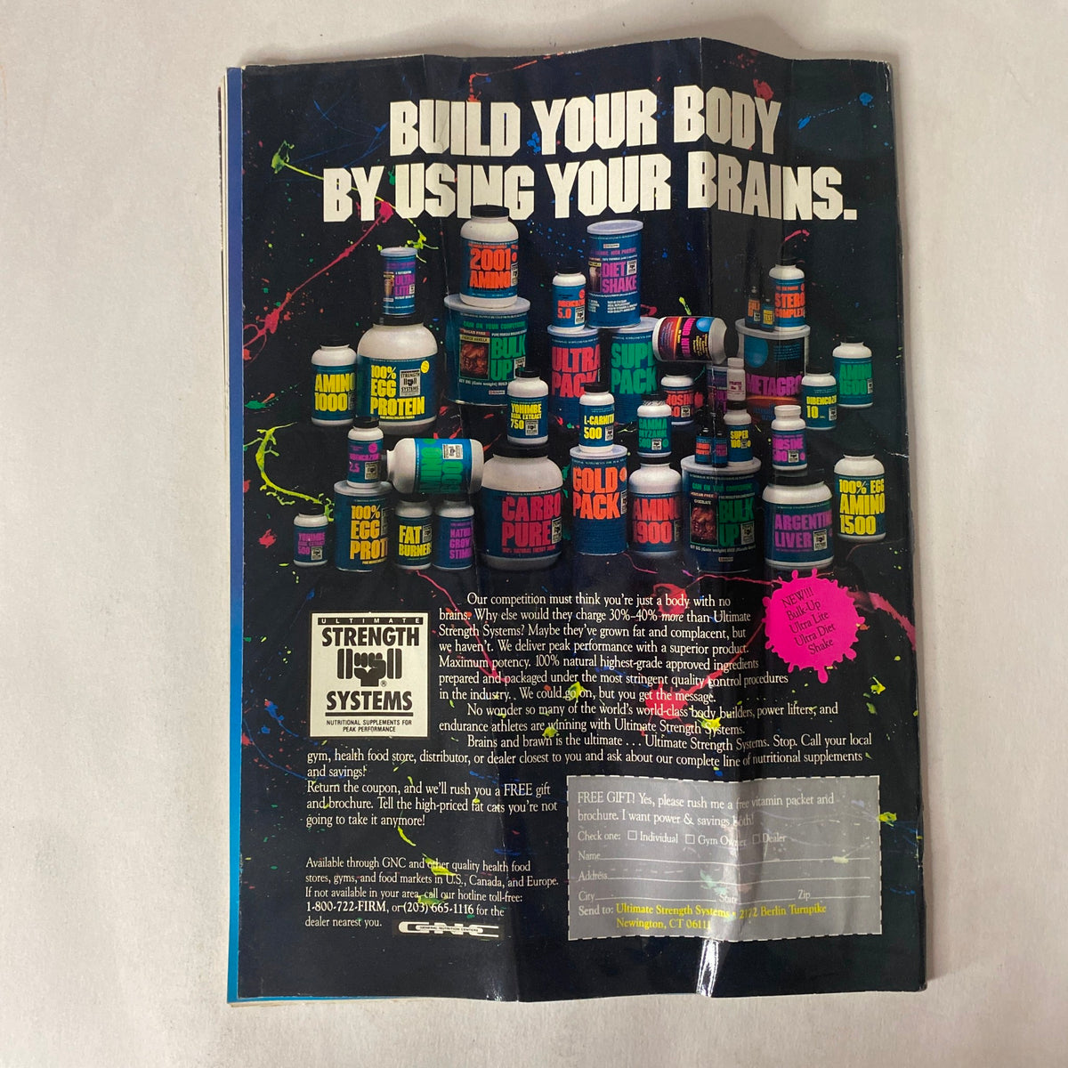 Advertisement for Strength Systems featuring a colorful array of nutritional supplements, promoting the message 'Build Your Body By Using Your Brains,' from Natural Physique Magazine November 1989 Vol. 2 No. 5 Tony Midea w Centerfold.