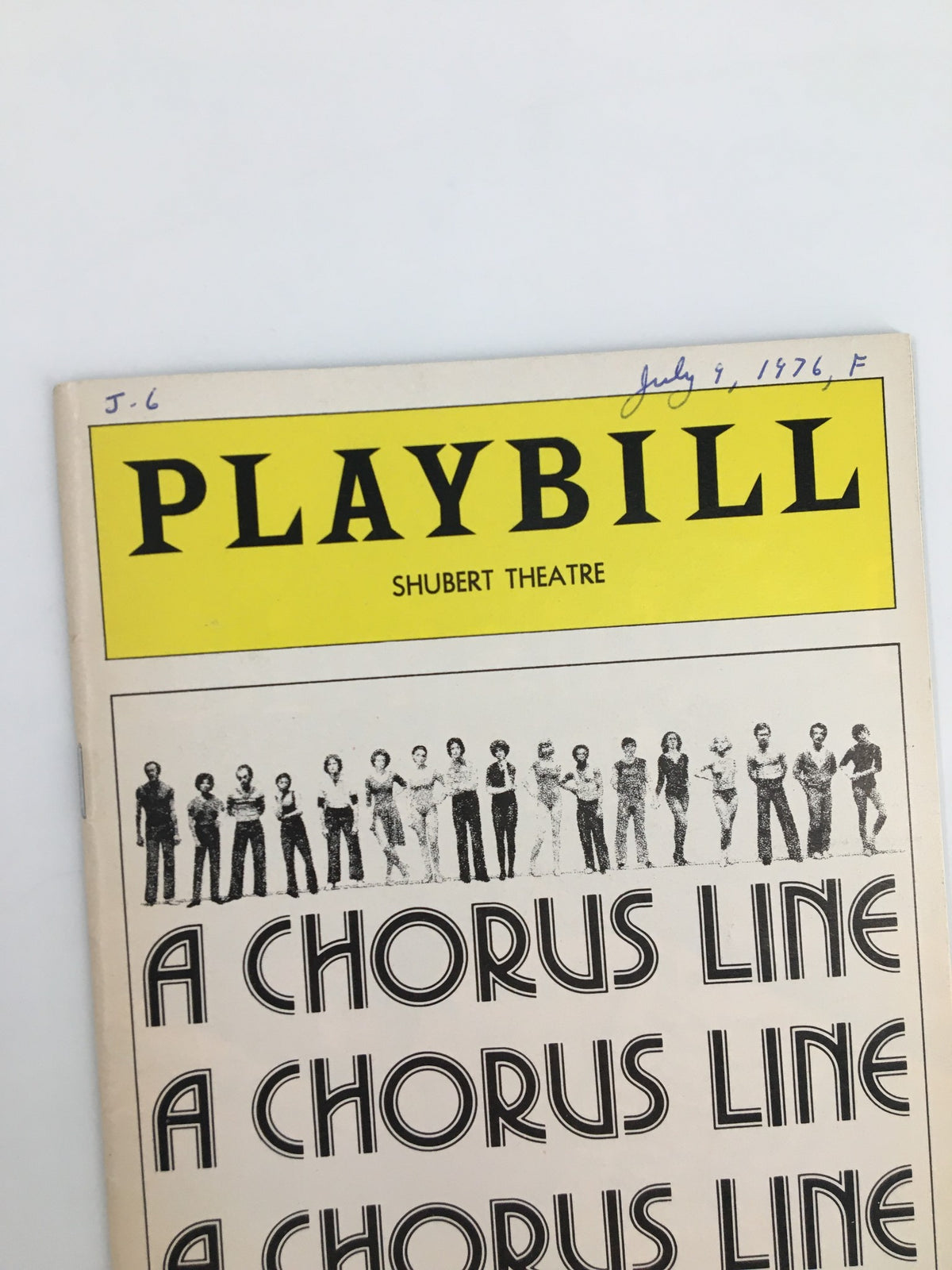 Close-up of the 1976 Playbill for A Chorus Line, showing the title and cast photo with handwritten date on the top.