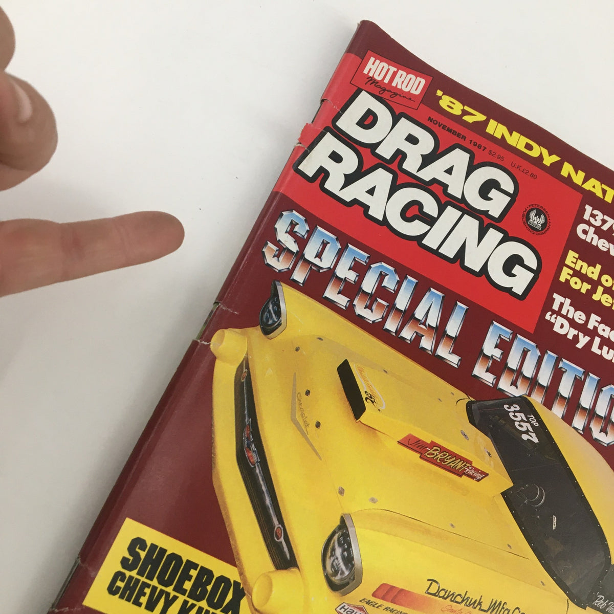 A close-up of the cover of Hot Rod Magazine Drag Racing November 1987, highlighting the yellow drag racing car and the statement 'SHOEBOX CHEVY KING!'