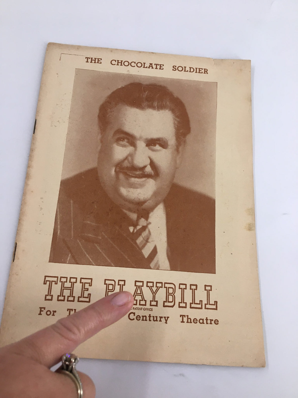 Close-up of the 1947 Playbill for The Chocolate Soldier, showcasing the cover design and a pointing hand, emphasizing the collectible nature of this theatrical piece.