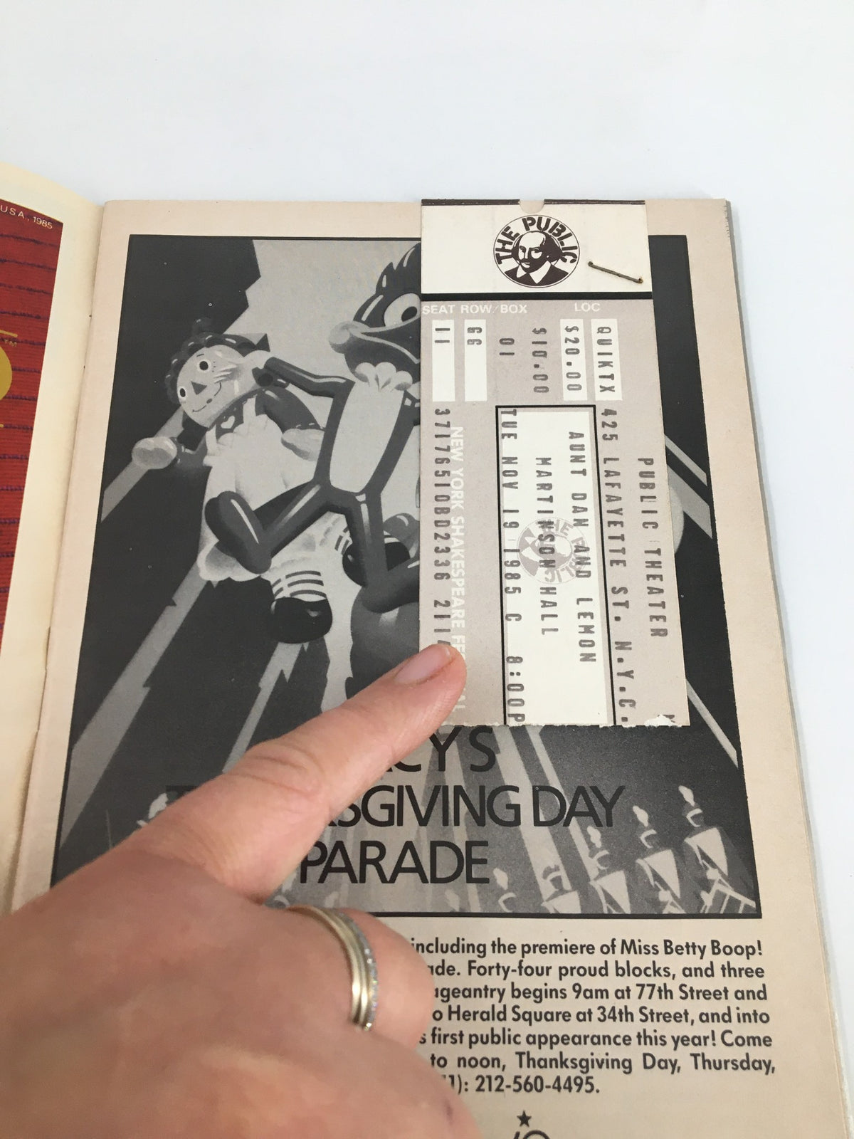 Hand pointing at the ticket for 'Aunt Dan and Lemon' showbill from the Public Theater, featuring the date November 19, 1985 and priced at $20.00.