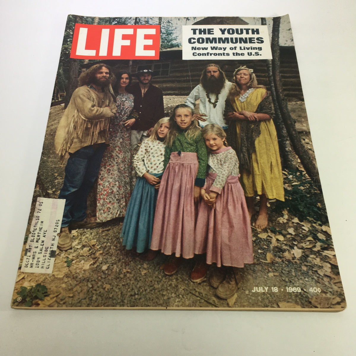 Vintage cover of Life Magazine from July 18, 1969, titled 'The Youth Communes,' featuring a group of individuals including adults and children in traditional attire, set outdoors with a rustic background, highlighting the counterculture and communal living of the 1960s.