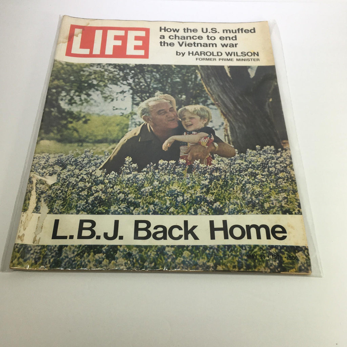 Cover of the Life Magazine issue from May 21, 1971, featuring the headline 'L.B.J. Back Home' and an article about how the U.S. ended the Vietnam War. The cover image depicts a man with a child surrounded by blue flowers, reflecting a moment of warmth amidst historical context.