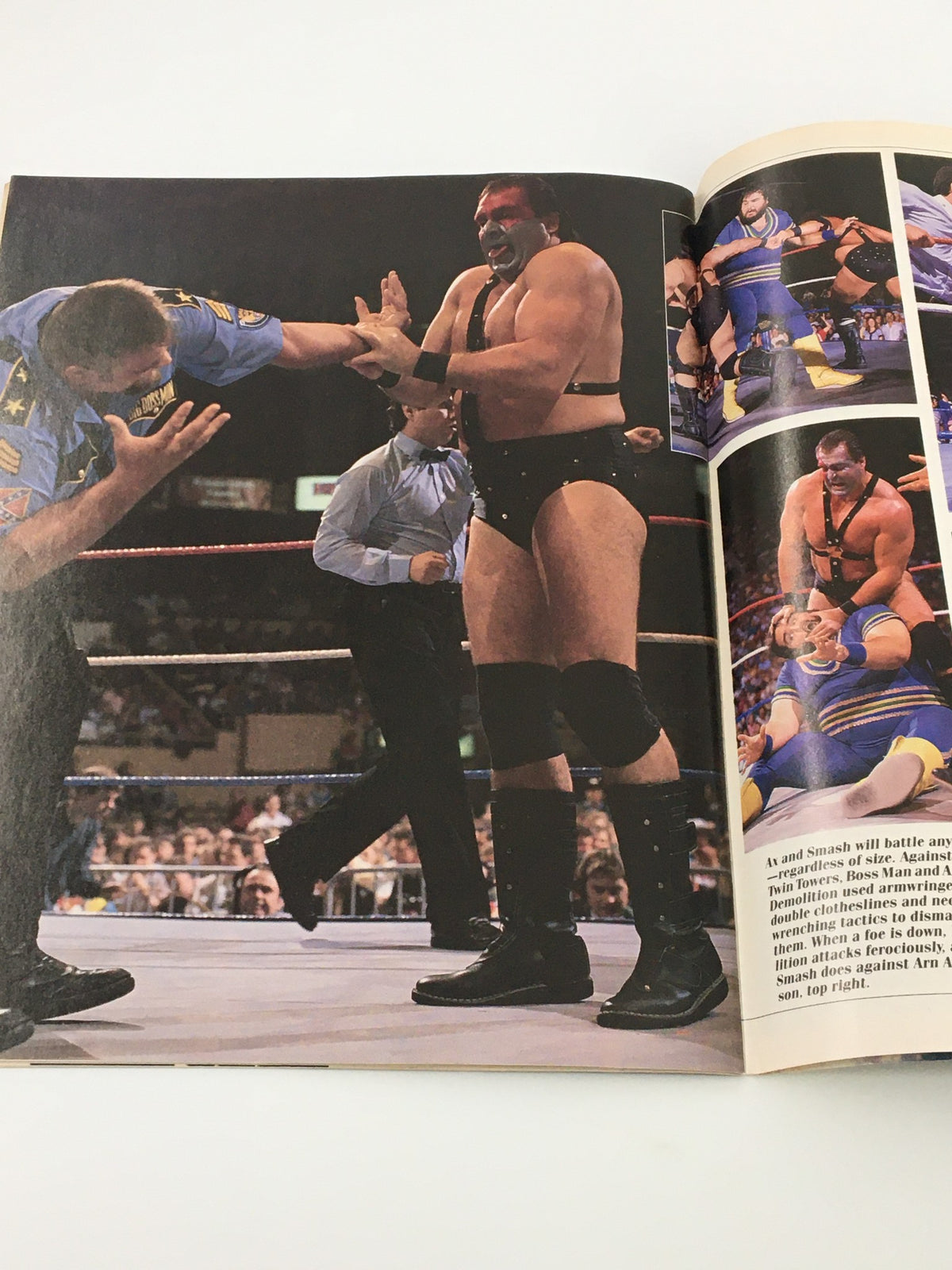 Action shot from Vintage WWF Wrestling Spotlight Magazine Volume 6 1989 featuring Demolition Ax and Smash during a wrestling match with referees and audience in the background.