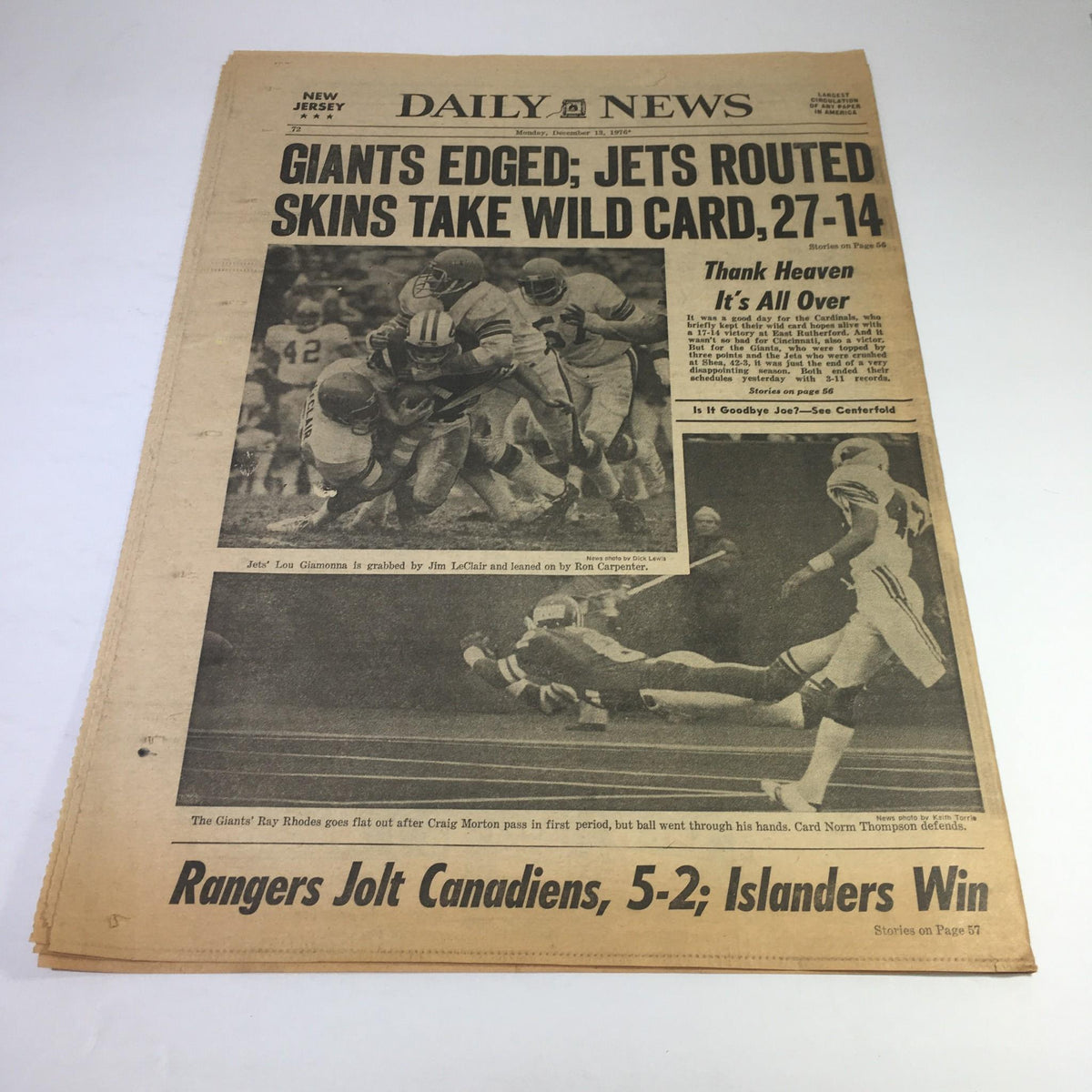 NY Daily News sports section from December 13, 1976, displaying the headline: 'Giants Edged; Jets Routed Skins Take Wild Card, 27-14'. The image captures a moment from a football game, showcasing the excitement of the sporting news from that era.