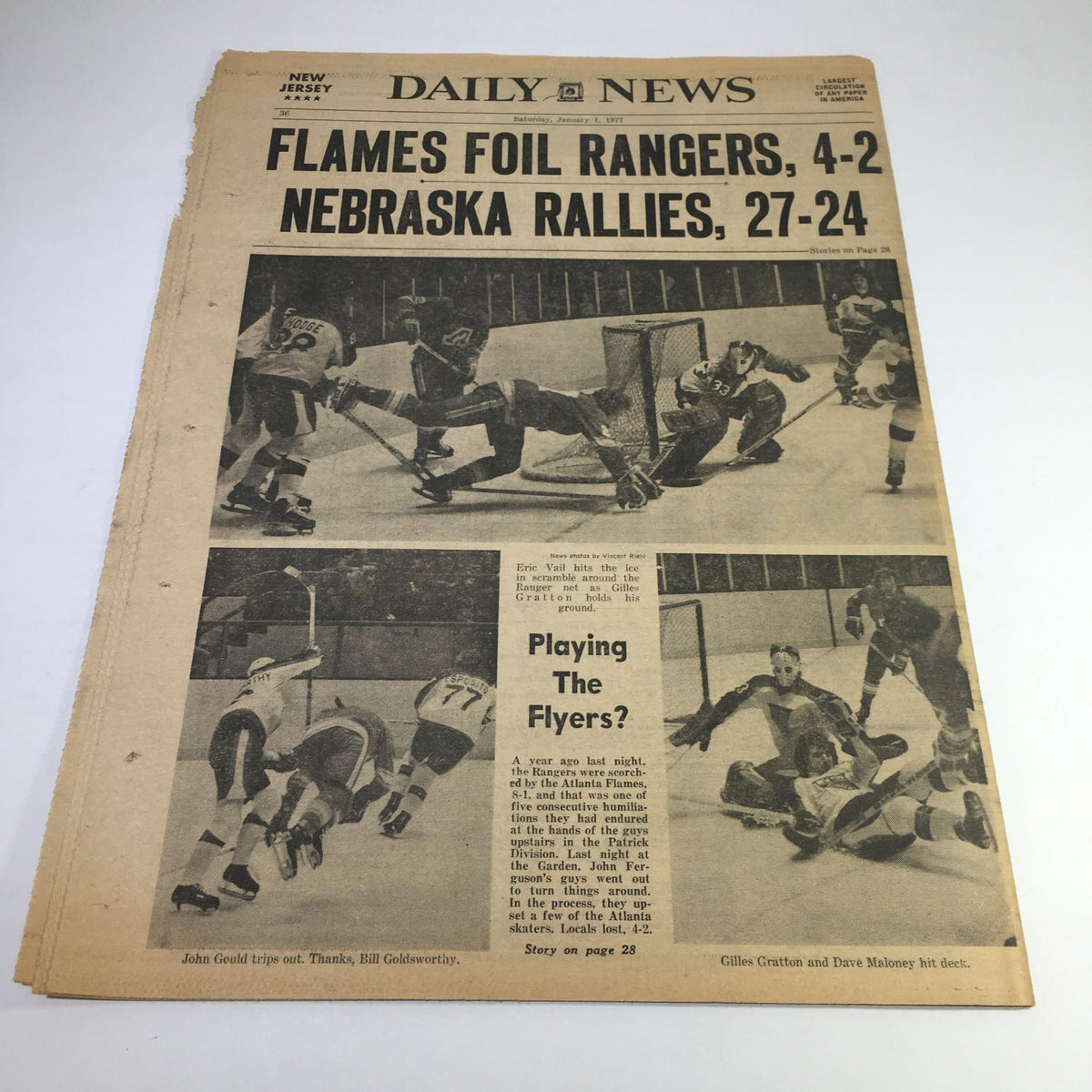 NY Daily News front page from January 1, 1977, showcasing the headline 'FLAMES FOIL RANGERS, 4-2 NEBRASKA RALLIES, 27-24' with a dynamic image of a hockey match in action, highlighting key sports events of the time.