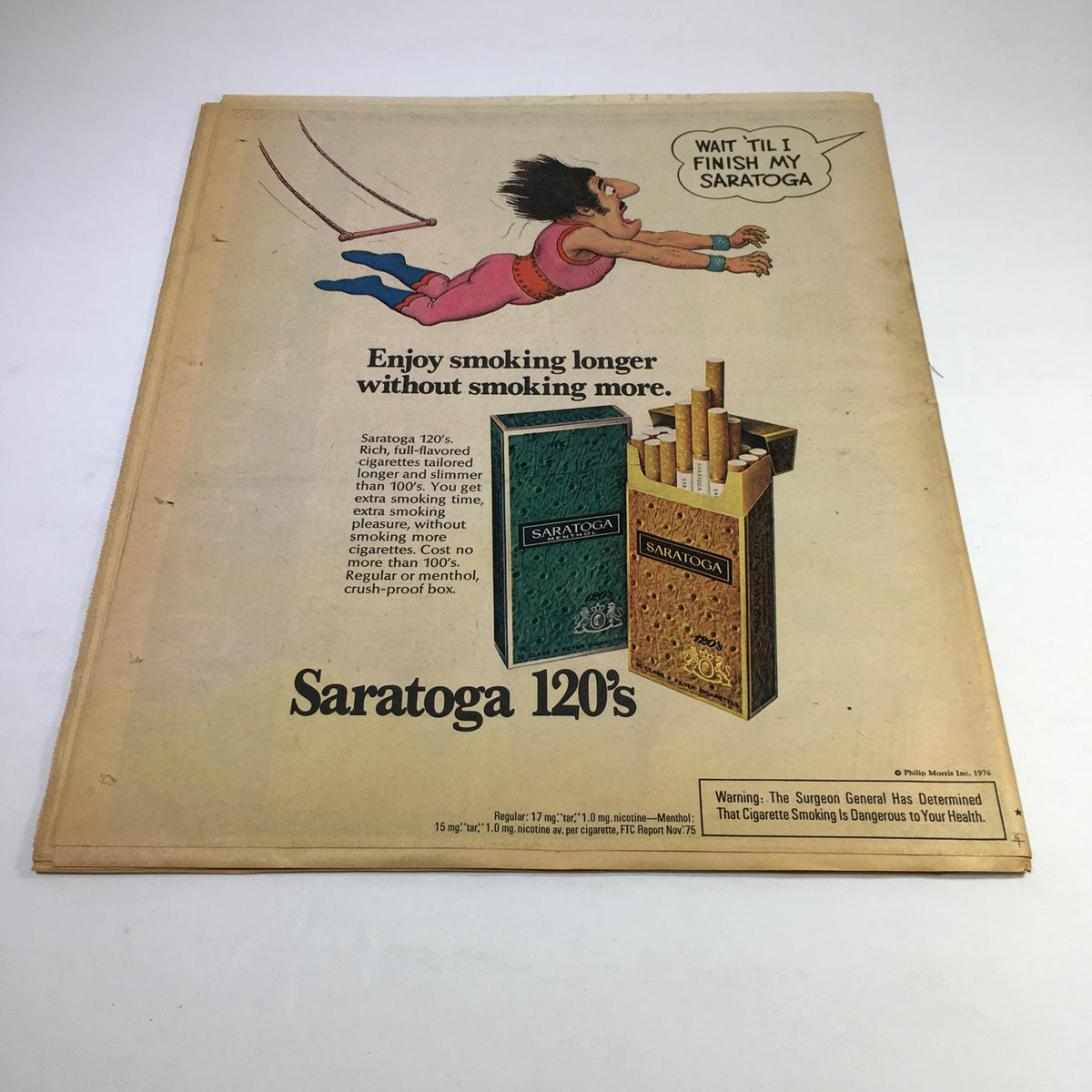 Advertisement for Saratoga 120's cigarettes from the Feb 15, 1976 issue of New York News Magazine, featuring a cartoon character swinging and enjoying smoking, with product details.