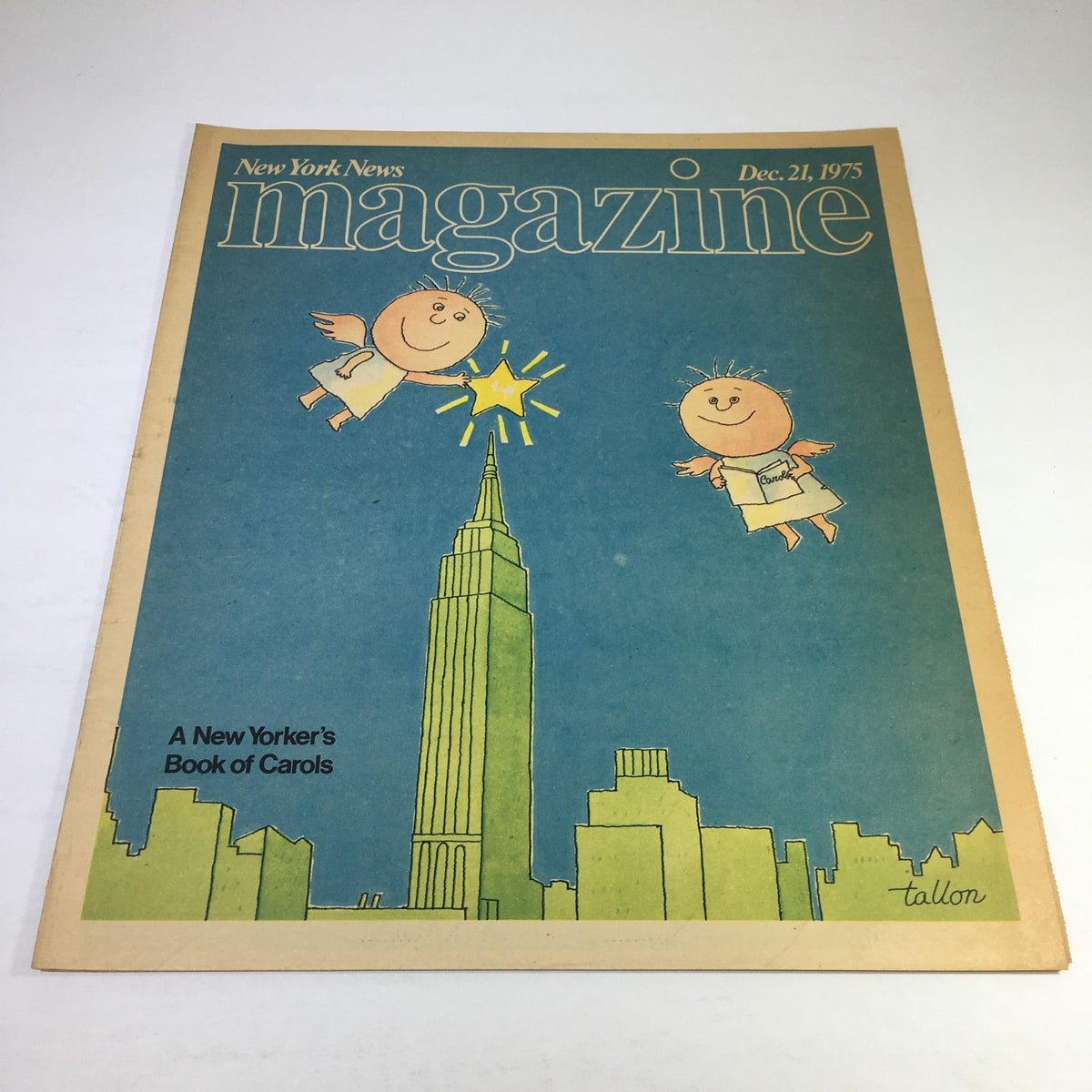 Cover of the New York News Magazine from December 21, 1975, featuring a playful illustration of children around the Empire State Building with the title 'A New Yorker's Book of Carols'.