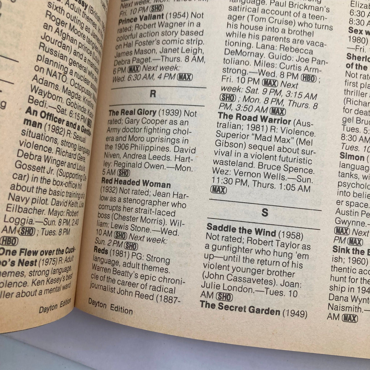 Inside page of TV Guide Magazine, July 28, 1984, showcasing a listing of TV shows and movies, highlighting titles like 'The Real Glory' and 'The Road Warrior', under the theme 'TV Guide Olympic Mischief Dayton Ed. No Label'.