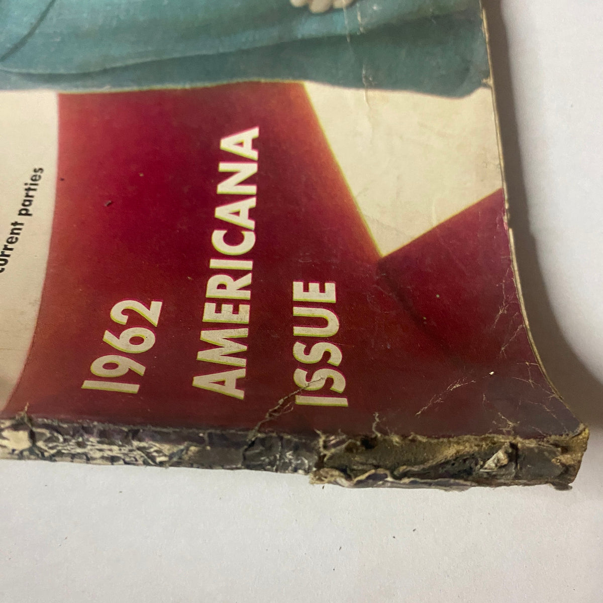 Close-up of the damaged spine of Vogue Magazine February 1, 1962 featuring Wilhelmina Cooper by Karen Radkai, showcasing the issue number and a vintage patina.