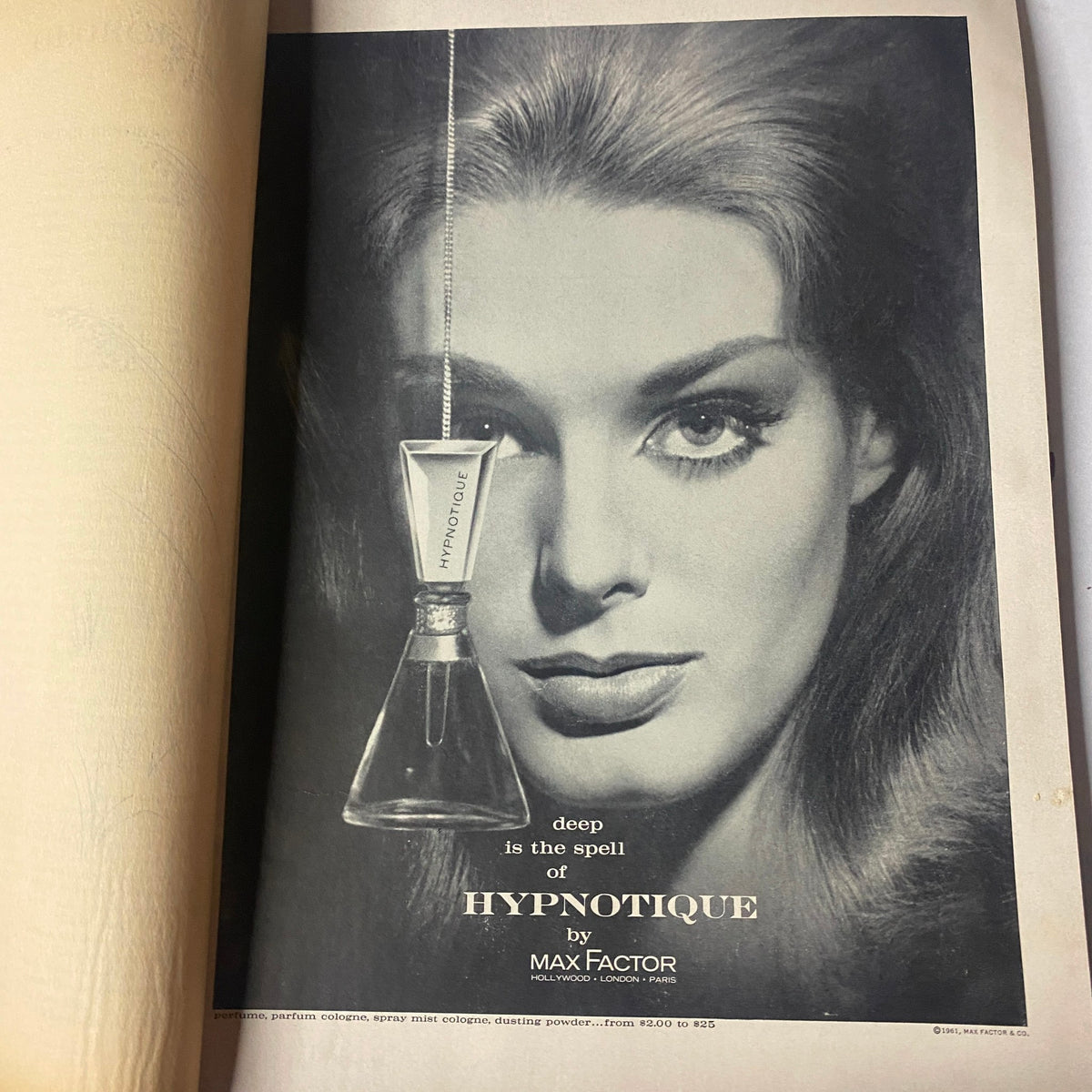 Advertisement for Hypnotique by Max Factor featured in Vogue Magazine May 1961, showcasing a glamorous model with striking makeup and beauty.