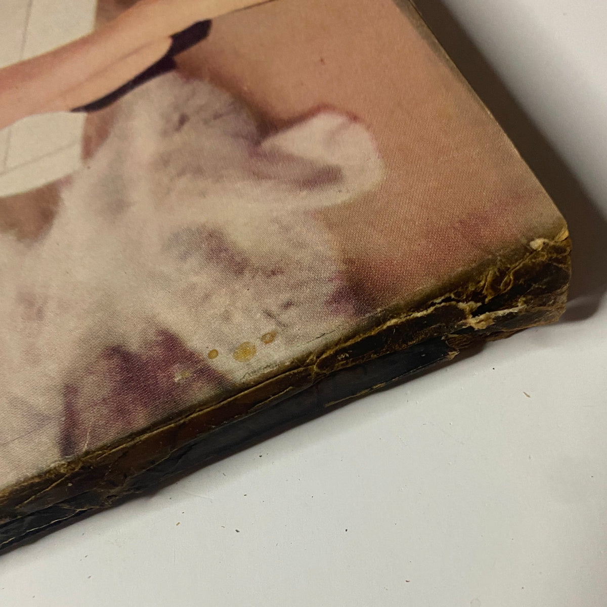 Detailed image showing the damage on the corner of the Vogue Magazine September 1, 1955 cover. This photograph captures the magazine's vintage characteristics, enhancing its value for collectors of mid-century fashion.