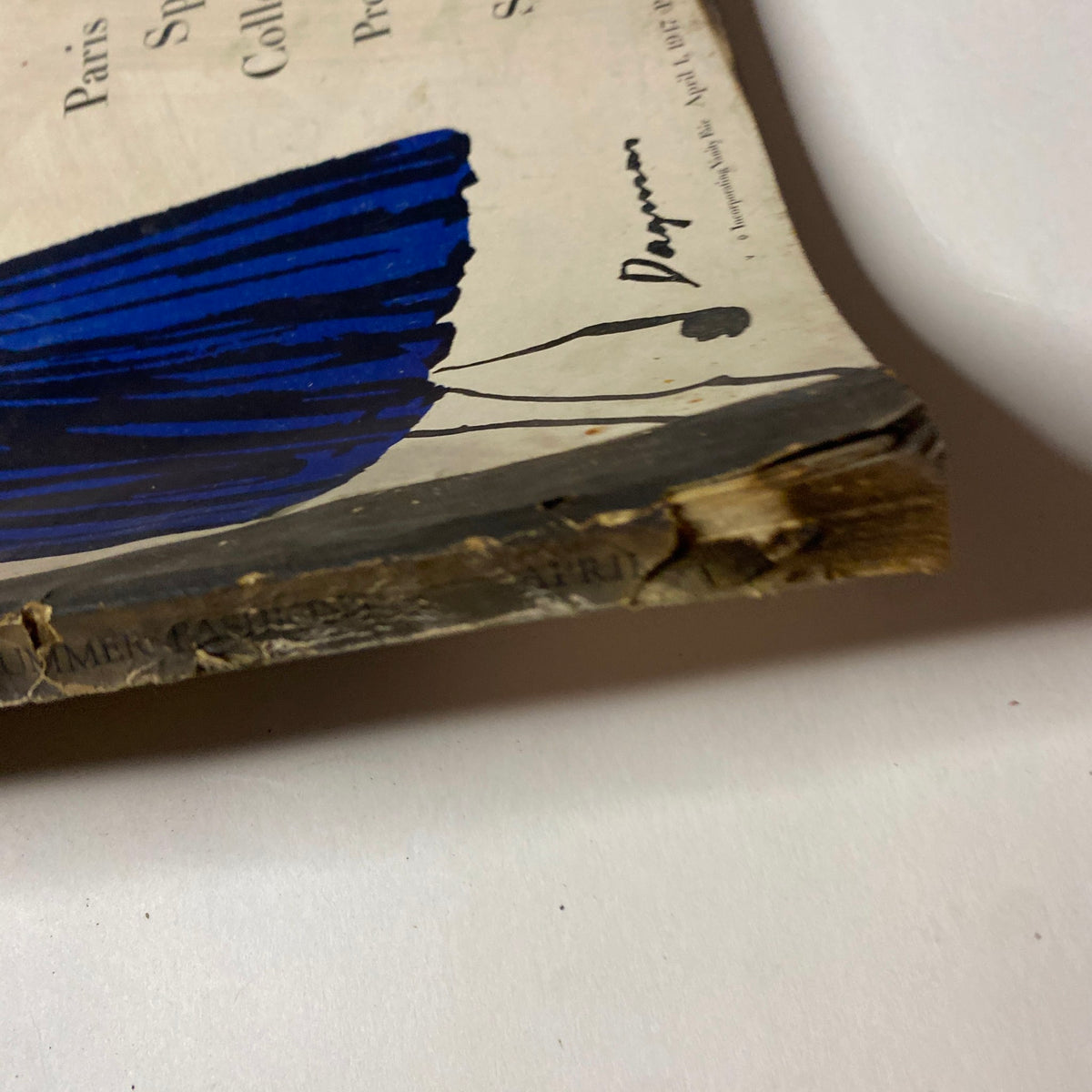 Close-up of the wear on the cover of Vogue Magazine April 1, 1947, showing damage near the spine and marked edges.