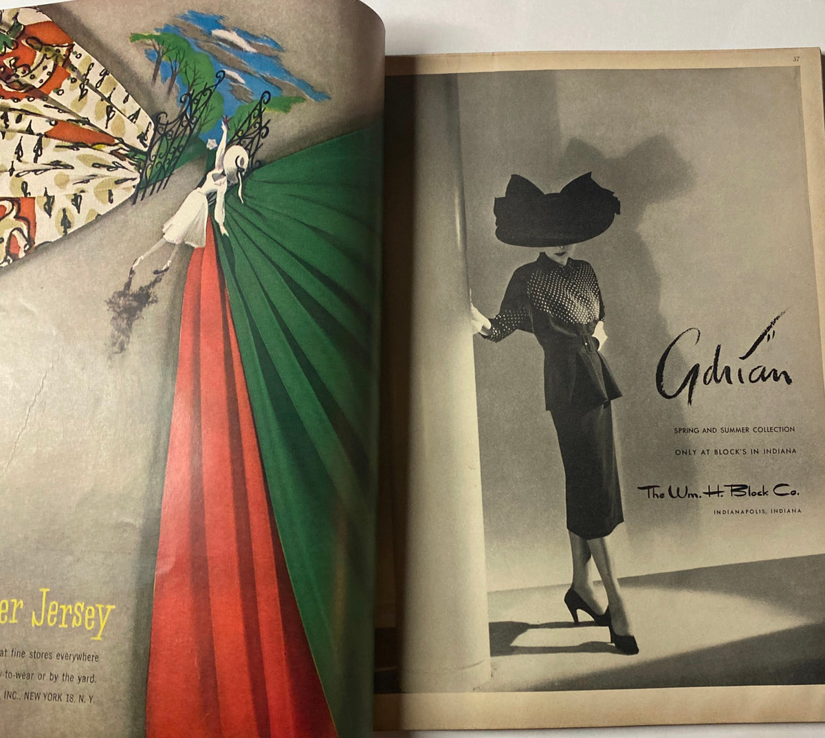 Adrian Spring and Summer Collection advertisement from Vogue Magazine April 1, 1947, showcasing a model in a stylish outfit standing against a vibrant colored backdrop that highlights the elegance of the fashion era.