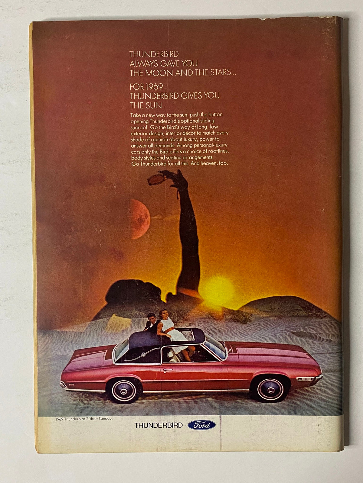 Back cover advertisement in The New Yorker Full Magazine April 12, 1969 for Ford Thunderbird, showcasing a couple relaxing by a car under a scenic sunset.