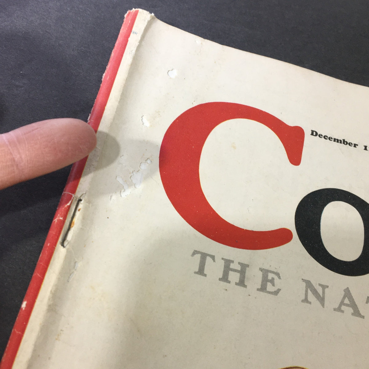 Close-up of the cover's edge of VTG Collier's Magazine December 12, 1936, showing minor wear and a finger pointing at its condition.