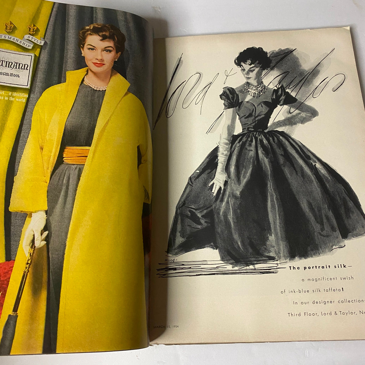 Vintage fashion advertisement featuring a model wearing a yellow coat and a black dress from the March 15, 1954 Vogue Magazine, showcasing elegance and style.