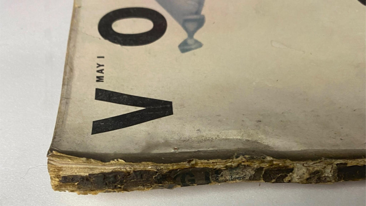 Close-up view of the spine of Vogue Magazine May 1, 1952, revealing wear and tear consistent with vintage magazine condition.