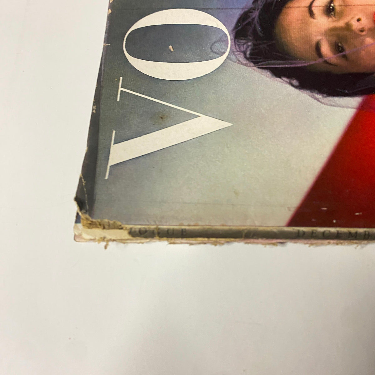 Close-up of the side spine of Vogue Magazine, December 15, 1942, showcasing wear on the binding and the iconic word 'VOGUE' in a stylish font.