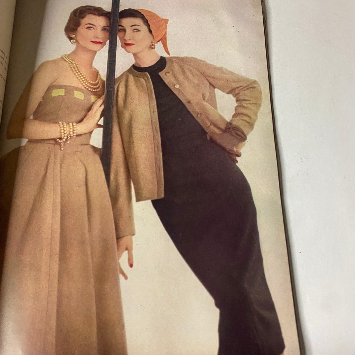 Fashion spread from Vogue Magazine August 15, 1952, showcasing elegant clothing styles modeled by two women, representative of collegiate fashion trends.