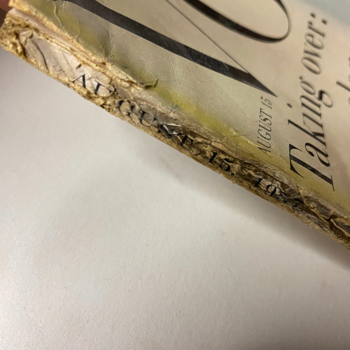 Side view of the spine of Vogue Magazine August 15, 1957, showing the publication date and signs of vintage wear.