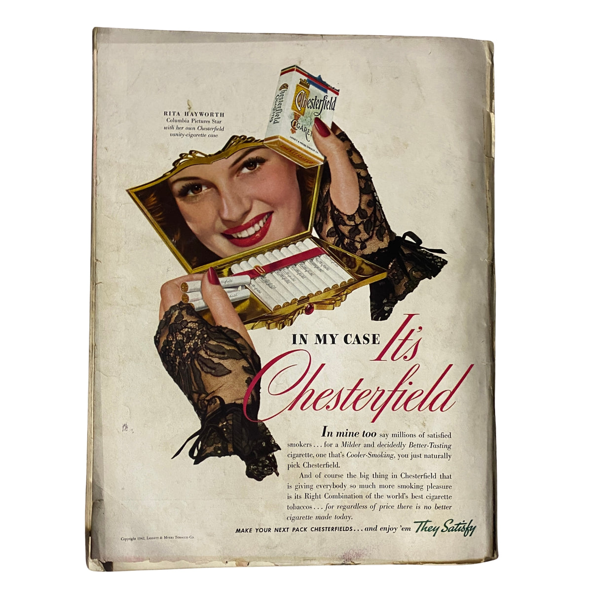 Advertisement from the April 15, 1942 issue of Vogue Magazine, featuring Chesterfield cigarettes, with a smiling model holding a decorative pack, showcasing early 1940s advertising style.