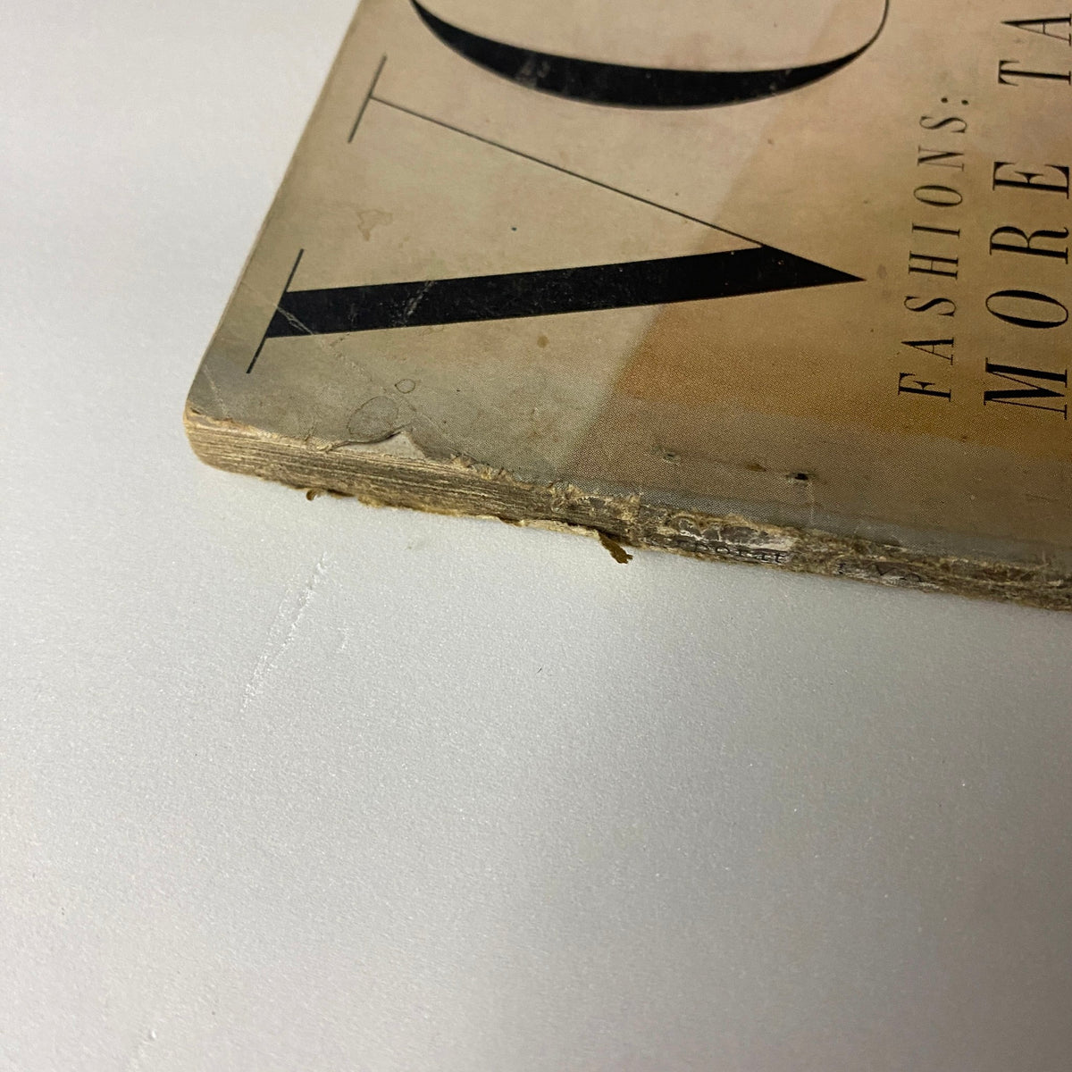 Detail of the Vogue Magazine October 15, 1950 Jean Patchett Cover by Horst P. Horst, showing the edge with wear and tear typical of vintage magazines.