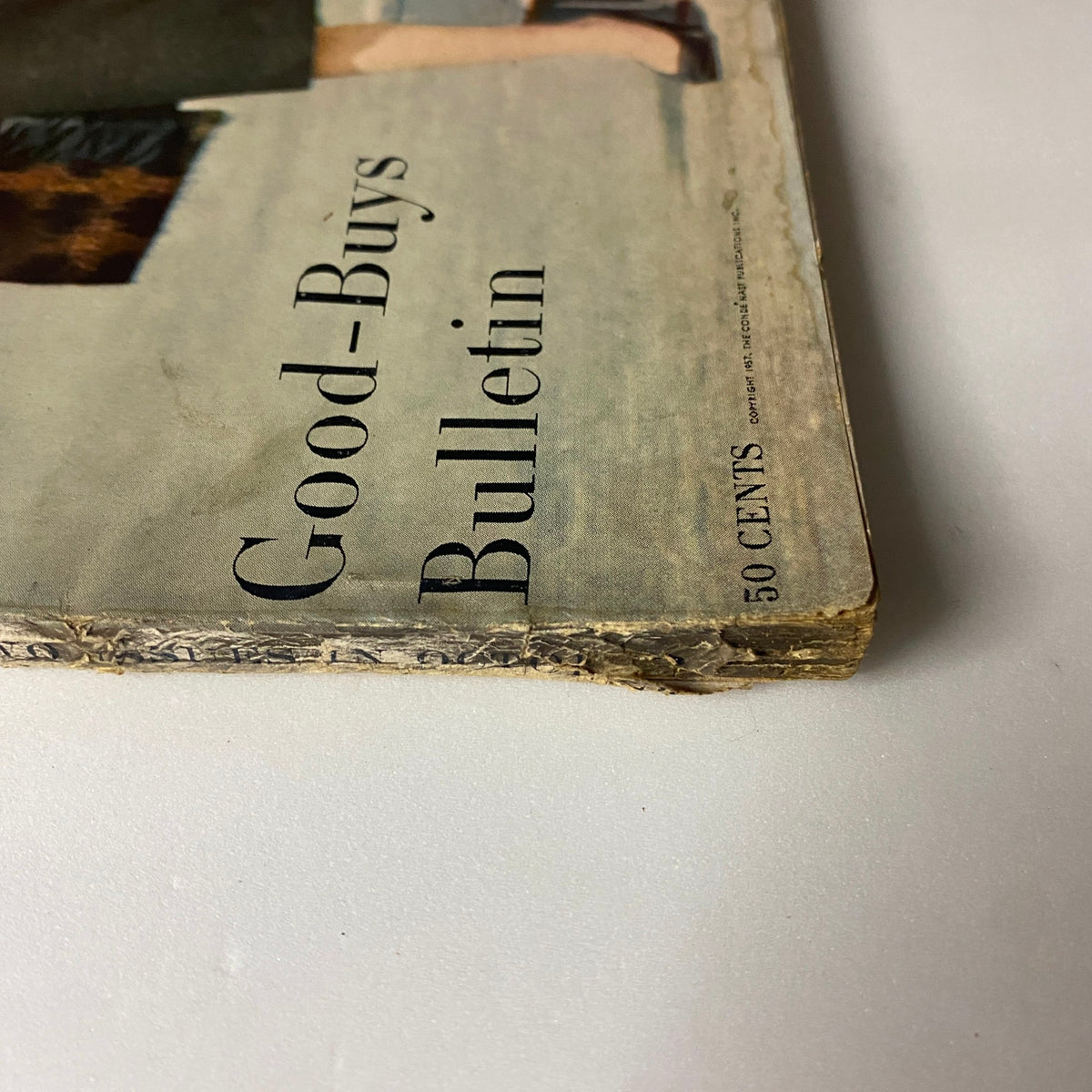 Bottom view of Vogue Magazine October 1, 1957, showing the title 'Good-Buys Bulletin' and characteristic edge wear.