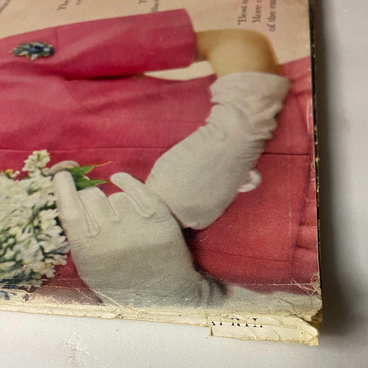 Detail of Vogue Magazine April 1, 1960 featuring model's gloved hands in pink attire, capturing mid-century fashion elegance.