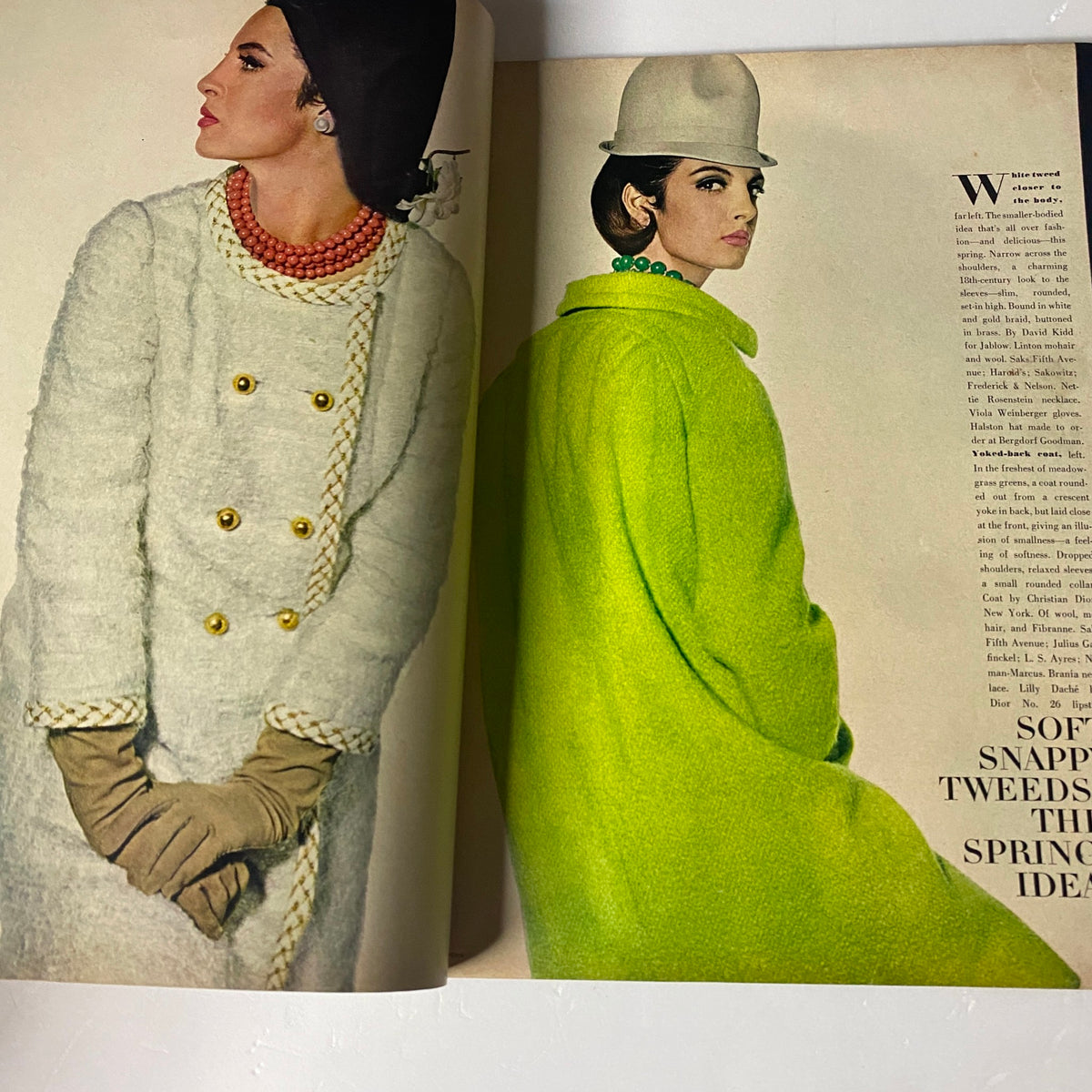 A fashion spread from Vogue Magazine January 15, 1964 featuring a model in a white coat, complemented by pearls and a green coat, demonstrating spring fashion trends.
