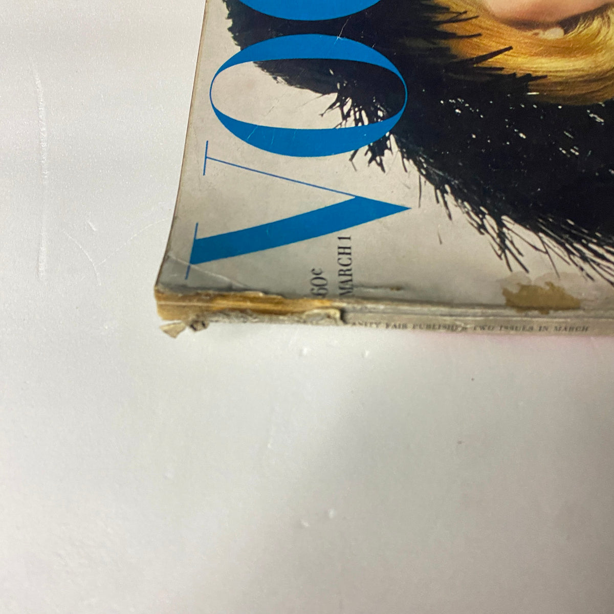 Close-up of the bottom corner of Vogue Magazine March 1, 1963, highlighting wear and tear on the spine, reflecting its vintage nature.