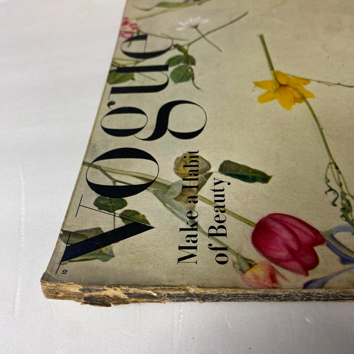 Detailed view of the vintage Vogue Magazine May 15, 1944 featuring Bettina Bolegard on the cover, with a close-up of the damaged spine.