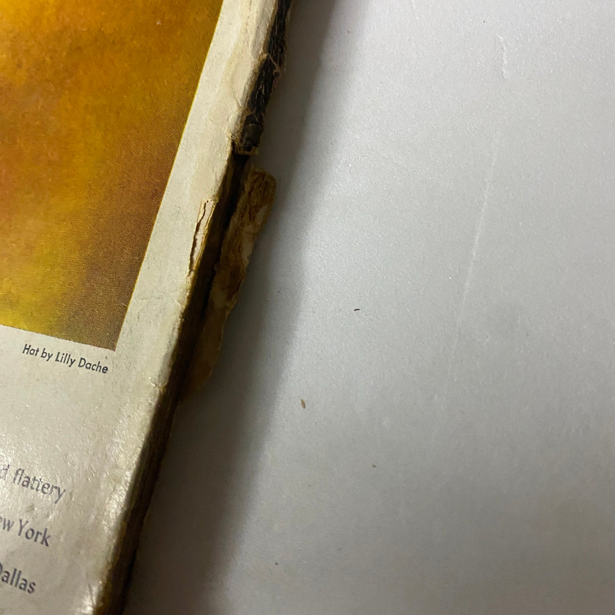 Close-up of the spine and edge of the Vogue Magazine May 15, 1944 featuring a hat by Lilly Dache, showing vintage wear and character.