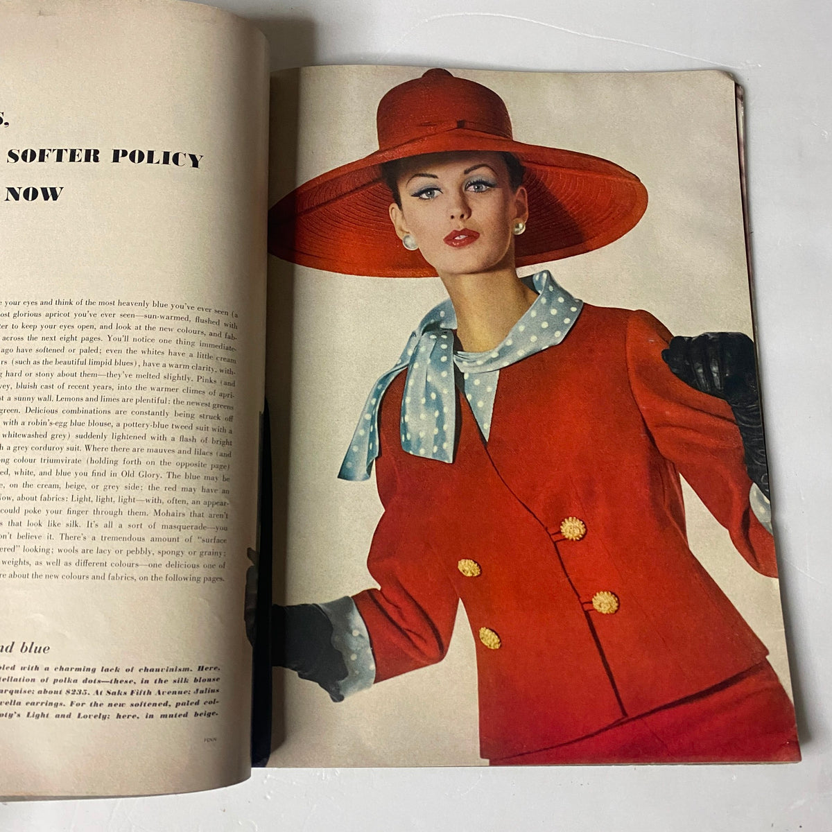 Fashion editorial from Vogue Magazine January 1, 1962, displaying a model in a stylish red outfit with a broad-brimmed hat.