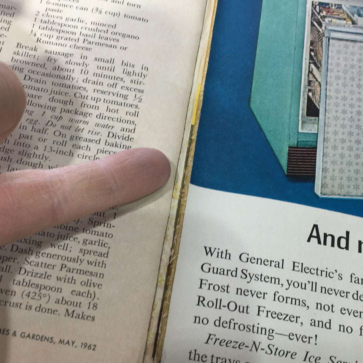 Close-up of a recipe page with finger pointing to instructions, from Better Homes & Gardens May 1962, focusing on pizza preparation steps.