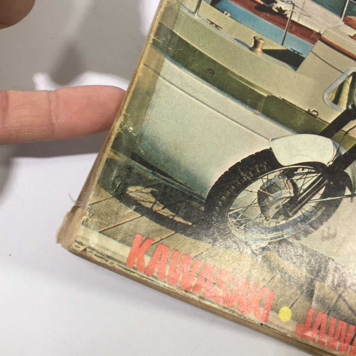 Close-up of the edge of the VTG Modern Cycle Magazine January 1968, highlighting minor wear and the prominent motorcycle brands mentioned, such as Kawasaki and Jawa.
