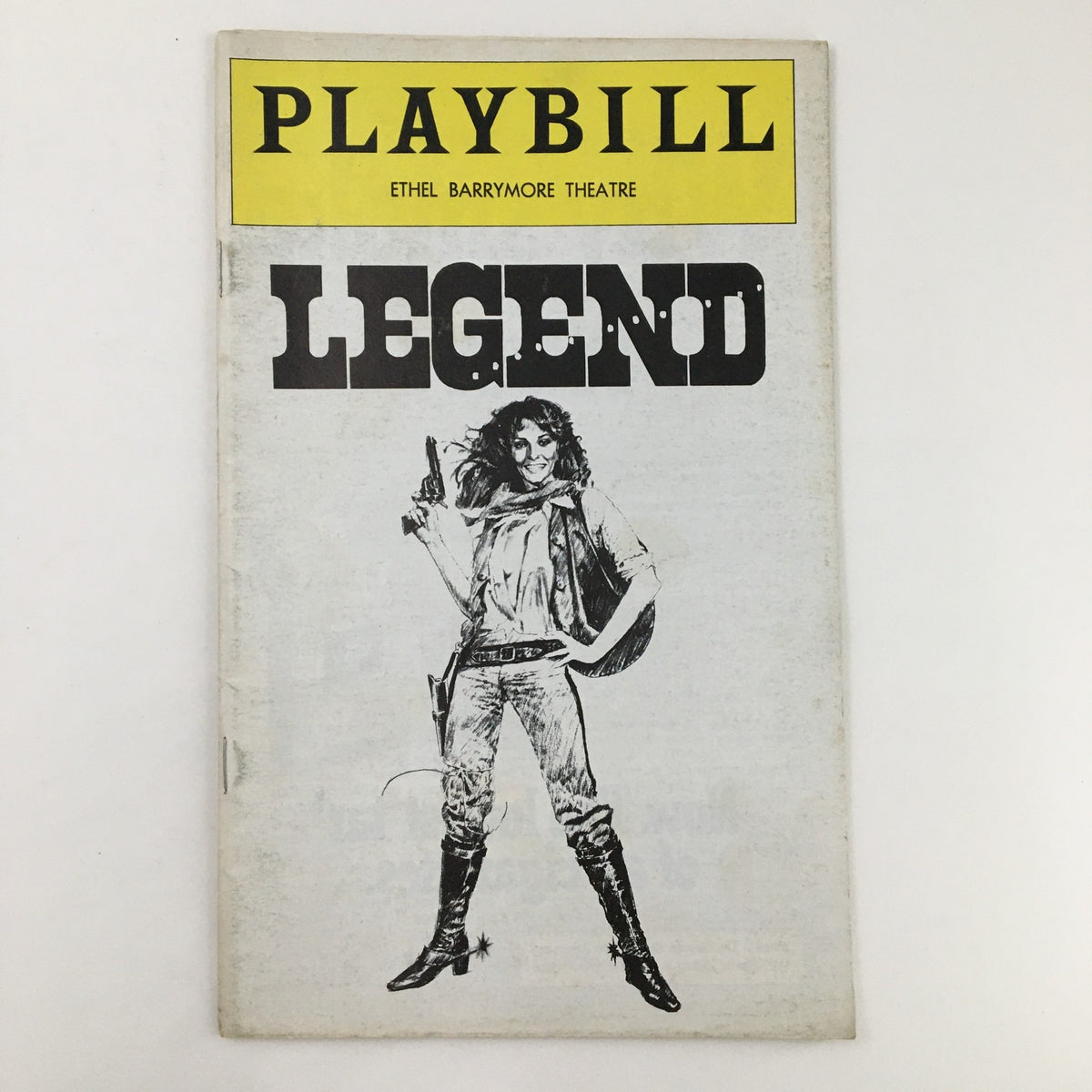 Front cover of the 1976 Playbill for 'Legend' featuring Ethel Barrymore Theatre, showcasing a dramatic illustration of a female character with a gun, reflecting the play's theme.