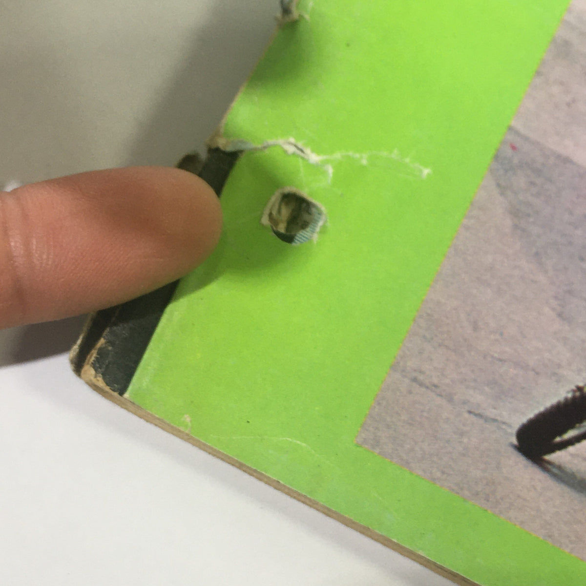Close-up of the edge of Cycle World Magazine January 1972, highlighting the wear and tear, including a small tear, indicative of its vintage condition.