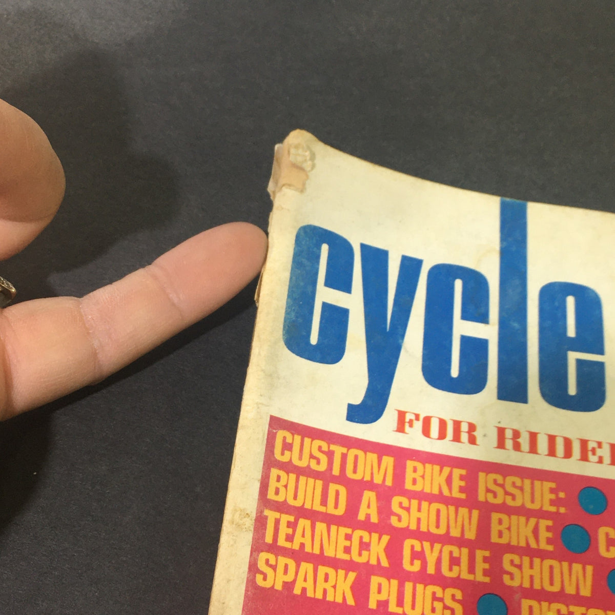 Close-up of the side of VTG Cycle Guide Magazine August 1967 showing minor wear on the cover, highlighting its vintage condition.