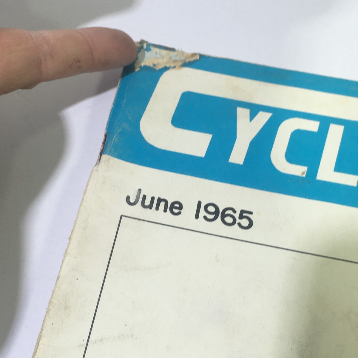 Close-up view of the top of the VTG Cycle Sport Magazine June 1965 showing the publication date and some wear on the cover.