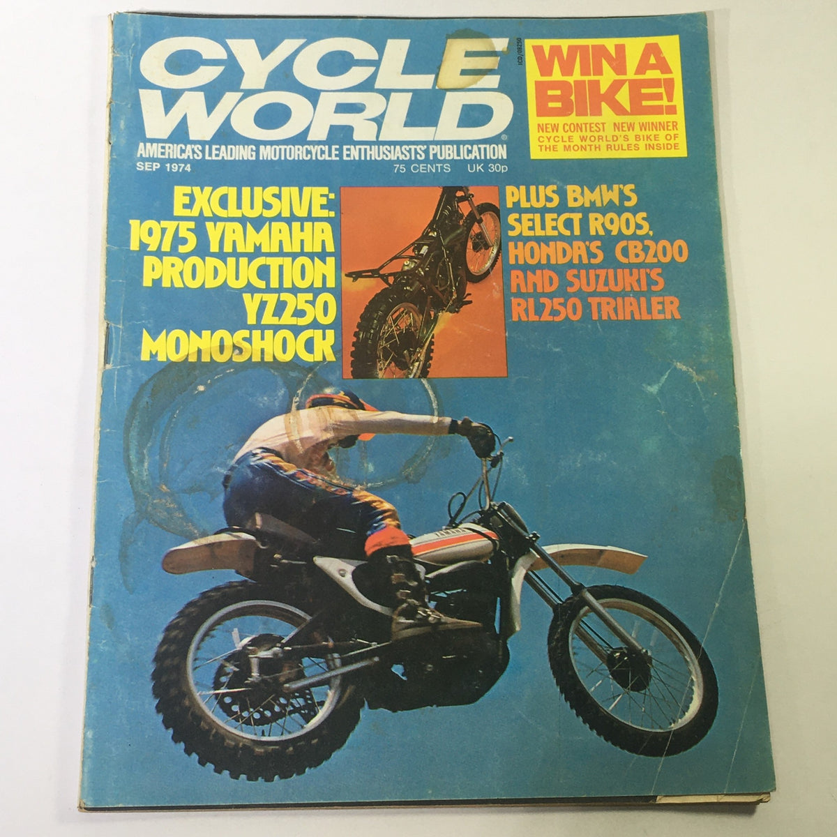 Cover of VTG Motor Cycle World Magazine September 1974 featuring the BMW R90S, Honda CB200, and RL250 with a striking design showcasing a motorcyclist riding a dirt bike.