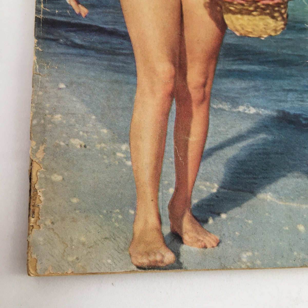 Close-up of the feet of Elizabeth Taylor on the beach in the Modern Screen Magazine July 1960 cover image, emphasizing the vintage seaside aesthetic.