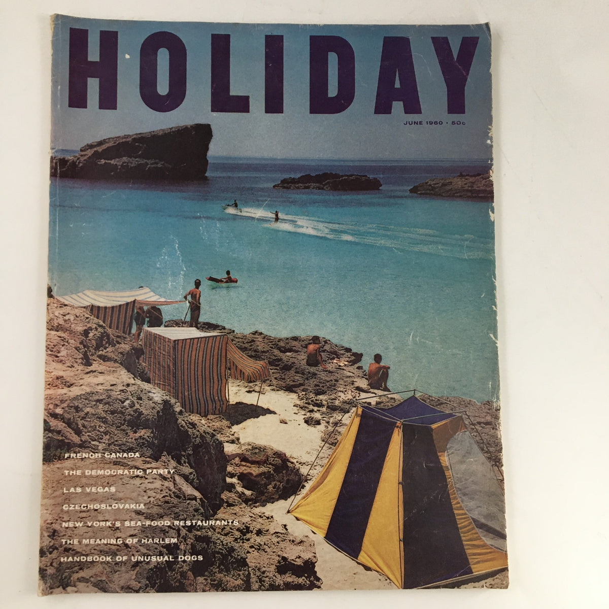Cover of Holiday Magazine June 1960 featuring a vibrant beach scene with colorful tents and people enjoying the ocean, highlighting New York's seafood restaurants.
