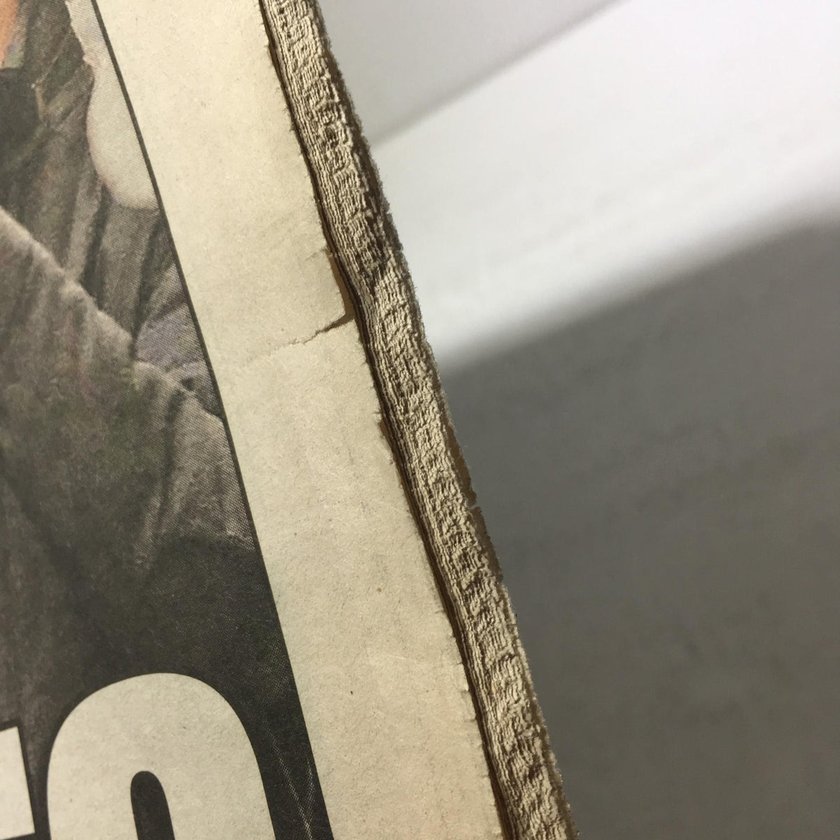Close-up of the edge of the New York Post newspaper, showing texture and mild wear, from Feb 8, 2012, featuring the headline 'Super Heroes City Salutes Champion Giants'.