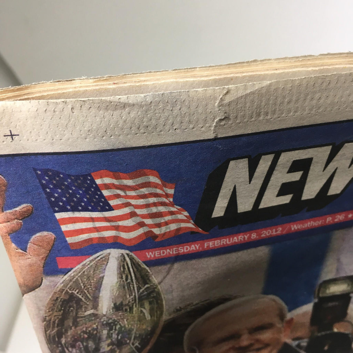 Top view of the New York Post dated Feb 8, 2012, with a visible American flag and the title 'New York Post' prominently displayed.