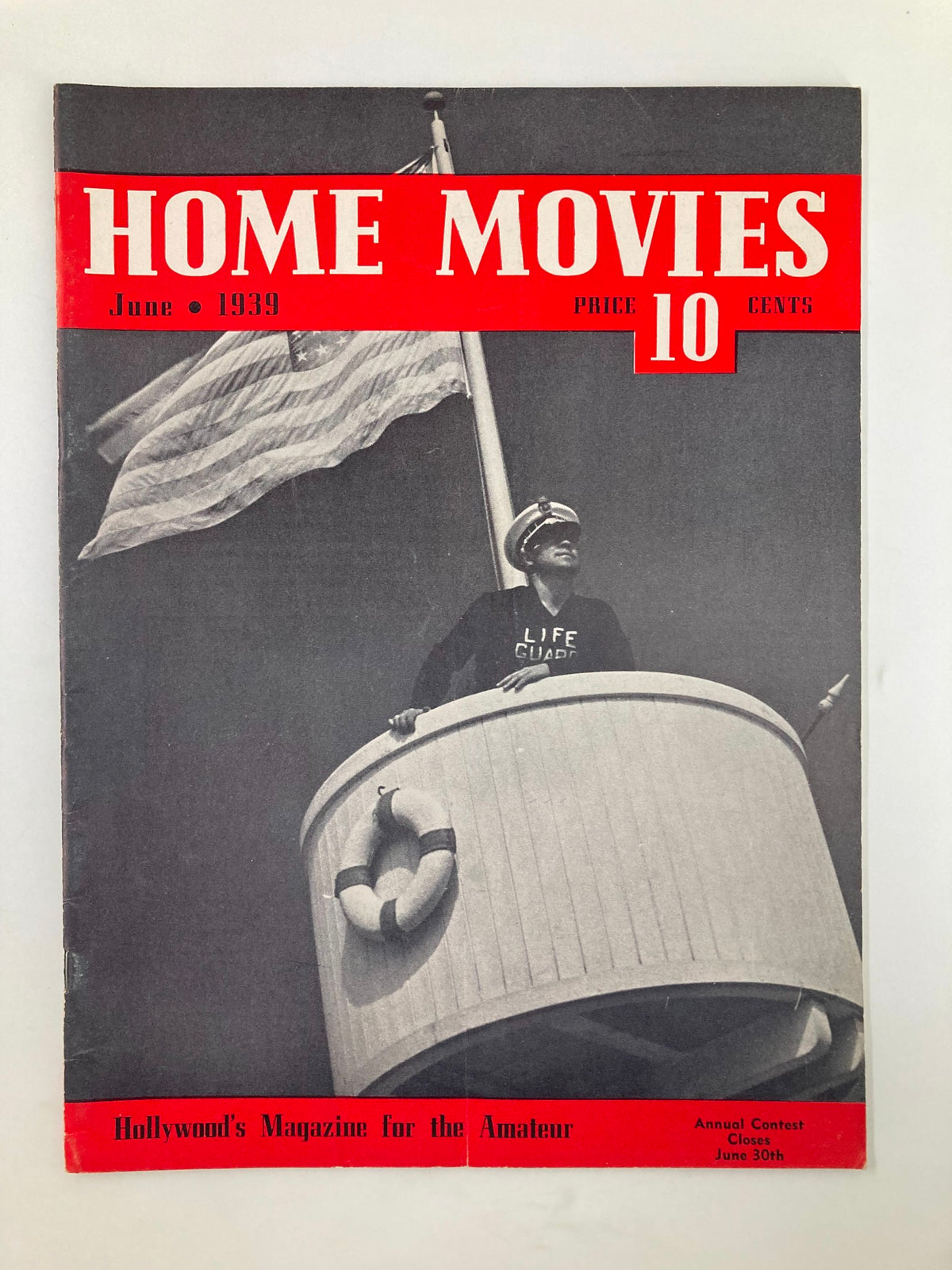 VTG Home Movies Magazine June 1939 cover showcasing a vintage design with a man in a lifeguard shirt, an American flag, and red lettering emphasizing the magazine's title and price.