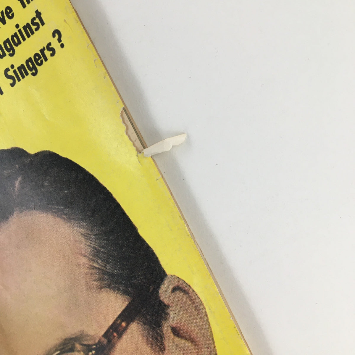 Detail of the edge of the TV Radio Mirror Magazine November 1957 cover, showing a small rip and the iconic yellow color scheme with text about girl singers.