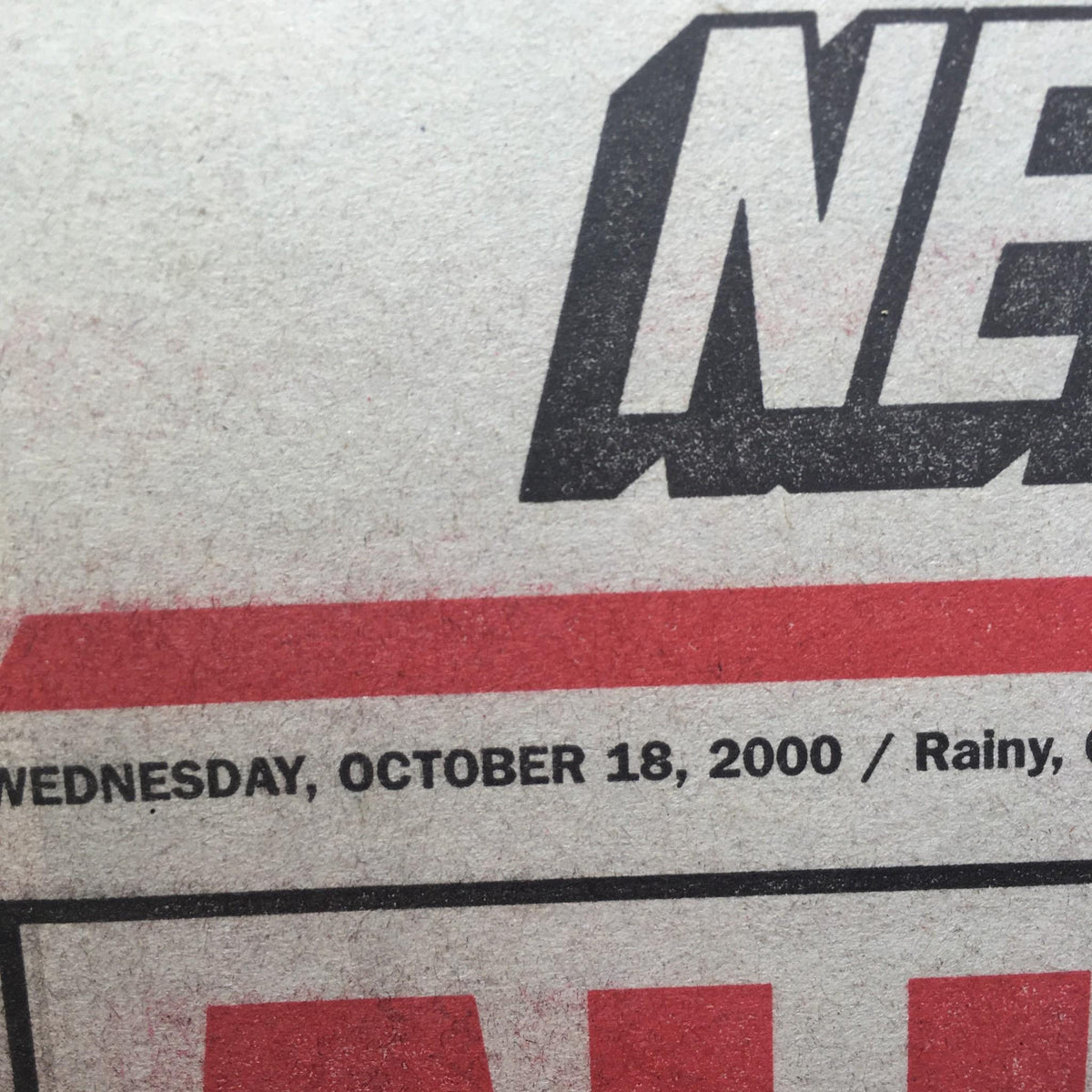 Close-up of the date on the New York Post newspaper from October 18, 2000, indicating it was a rainy day and important sports news.