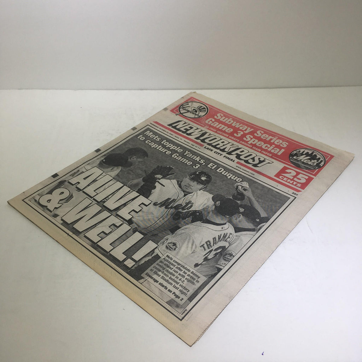 Front page of the New York Post titled 'NY Post: 10/25/2000 Mets topple Yanks, El Duque to capture Game 3, Excellent'. The image captures the excitement of the Subway Series Game 3 with players celebrating.