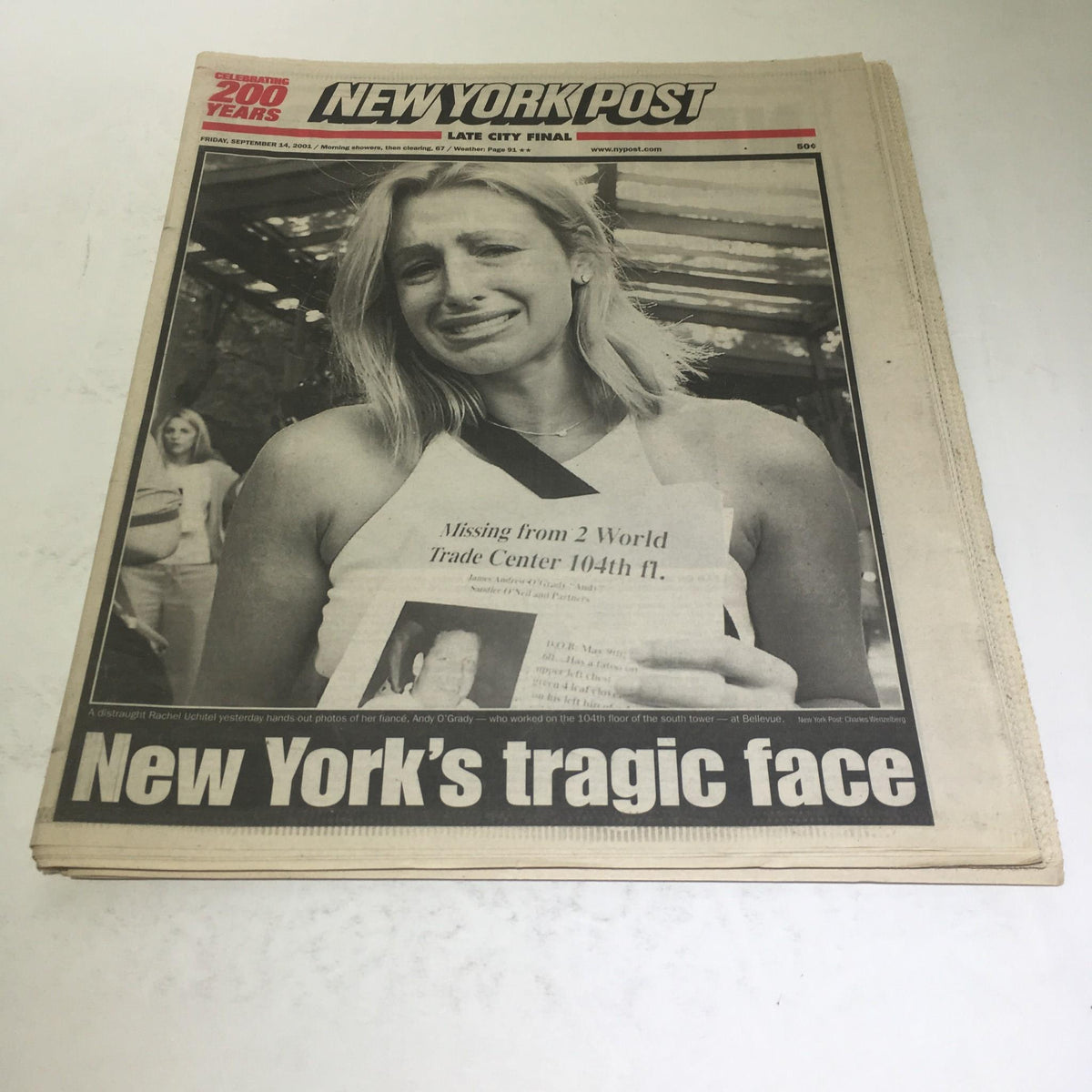 New York Post front page featuring the emotional headline 'New York's Tragic Face' from September 14, 2001, capturing a poignant moment following the events of September 11. A woman is seen holding a missing person poster, reflecting the somber atmosphere of the time.